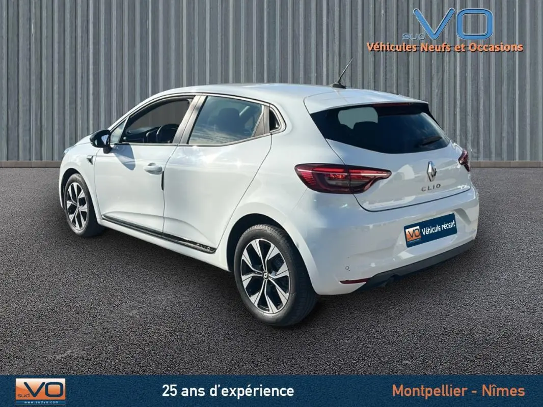Vue 3/4 arrière gauche d'une Renault Clio blanche 2021 avec jantes alliage 16 pouces et vitres teintées.