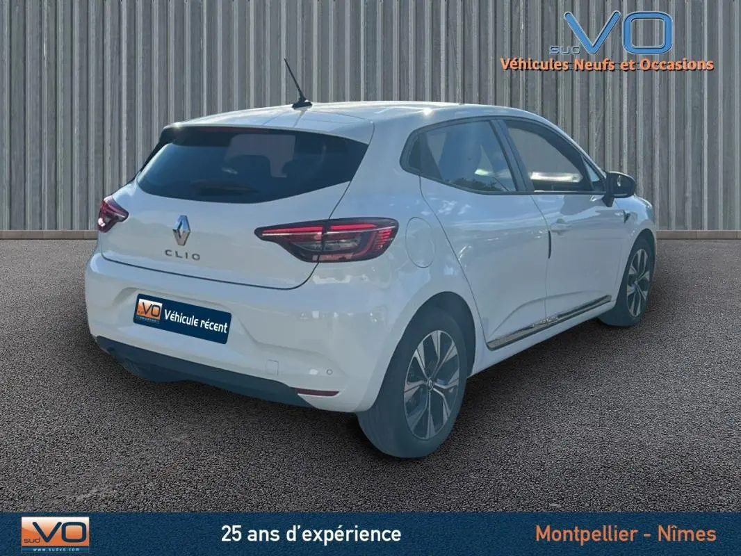 Renault Clio V TCe 90 blanc vue 3/4 arrière droit, jantes alliage 16 pouces, stationnement assisté visible