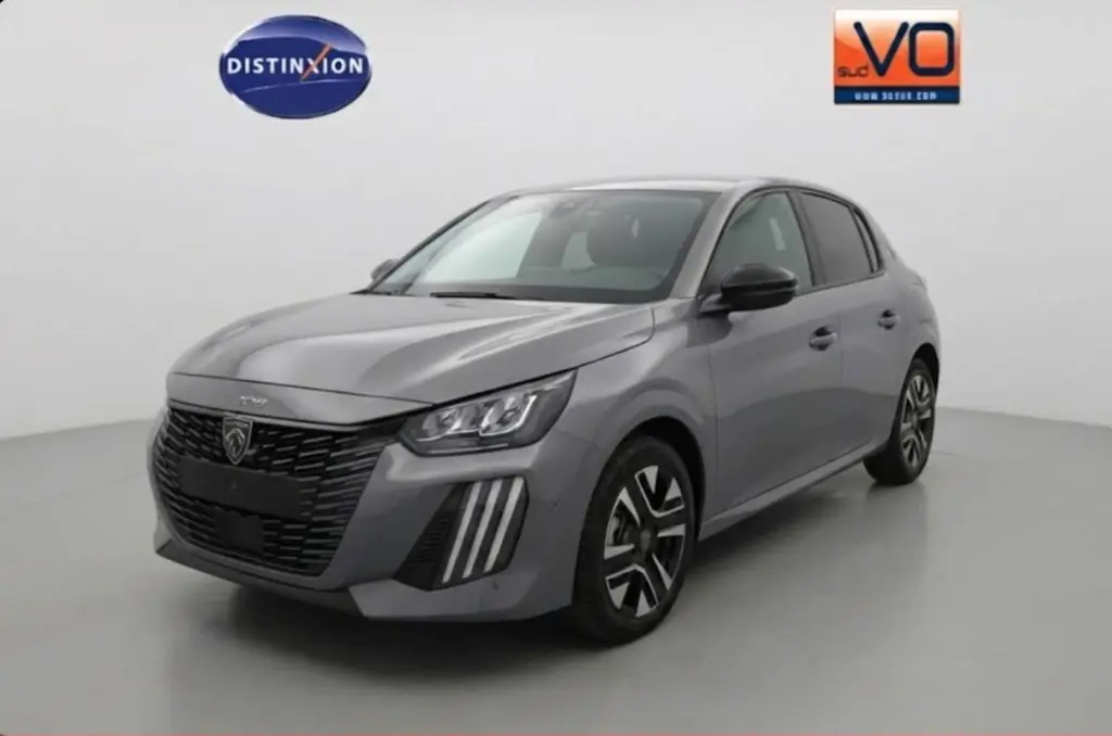 Peugeot 208 Hybrid gris en 3/4 avant droit, avec calandre noire et jantes alliage 16 pouces visibles.