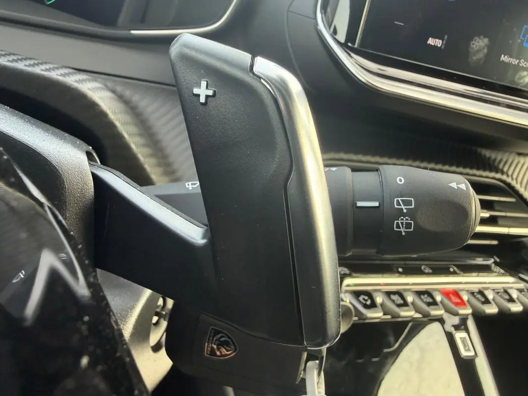 Gros plan sur la palette de changement de vitesse droite dans l’habitacle gris d’une Peugeot 208 Hybrid 110 e-DCS6 Allure 2025.