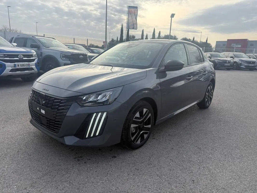 Peugeot 208 Hybrid gris vue 3/4 avant droit, avec feux diurnes à LED et jantes alliage 16 pouces.