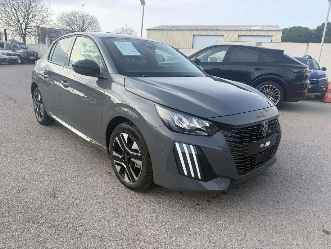 Peugeot 208 gris vue 3/4 avant droit, avec calandre noire et feux diurnes à LED distinctifs.