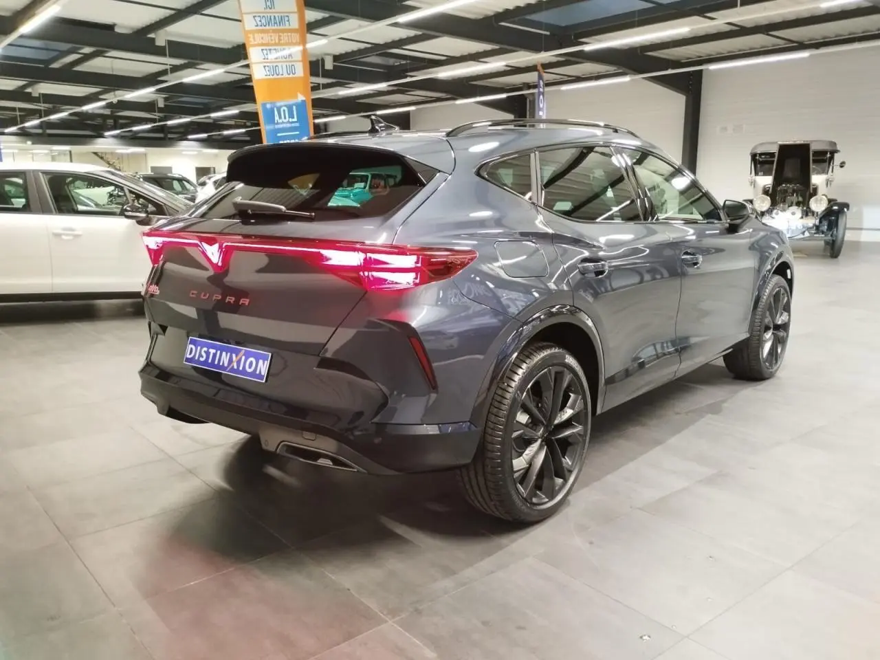 Vue 3/4 arrière droite du CUPRA Formentor 2026 Magnetic Tech avec feux arrière Tri-LED et jantes 19'' noires.