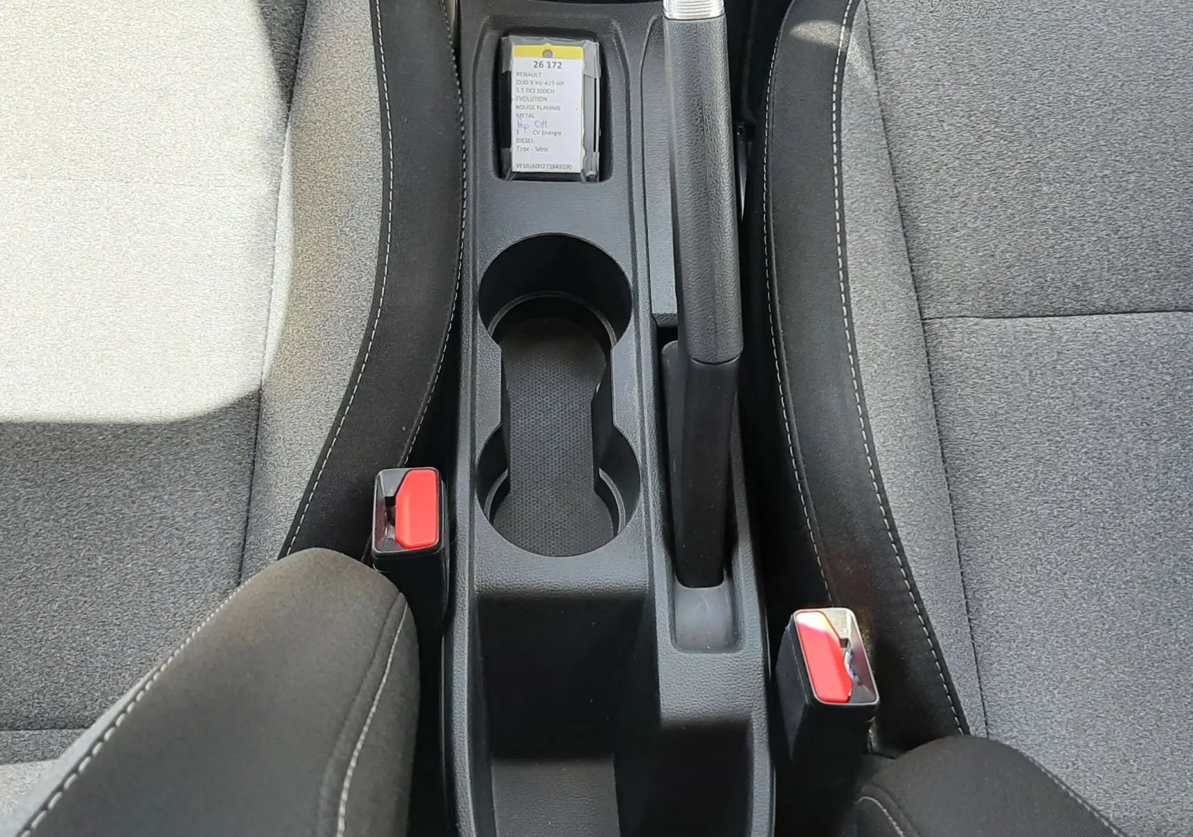 Vue plongeante sur la console centrale et les sièges gris tissu de la Renault Clio V DCI 100ch Evolution.