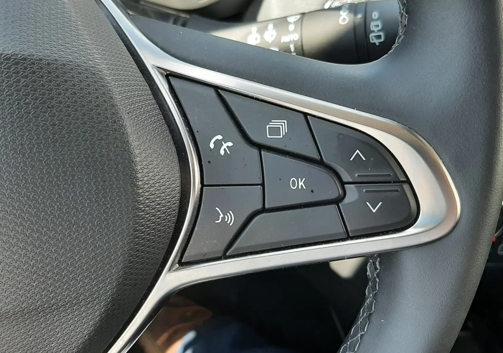 Gros plan sur les commandes au volant côté droit de la Renault Clio V 2024, cuir noir et boutons multifonctions.