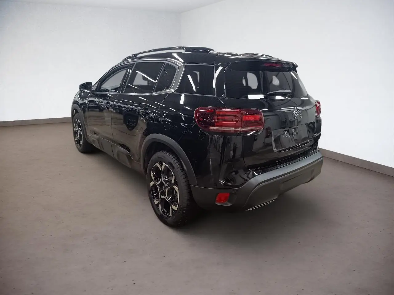 Vue 3/4 arrière gauche du Citroën C5 Aircross Hybrid noir Perla avec jantes diamantées et vitres surteintées.