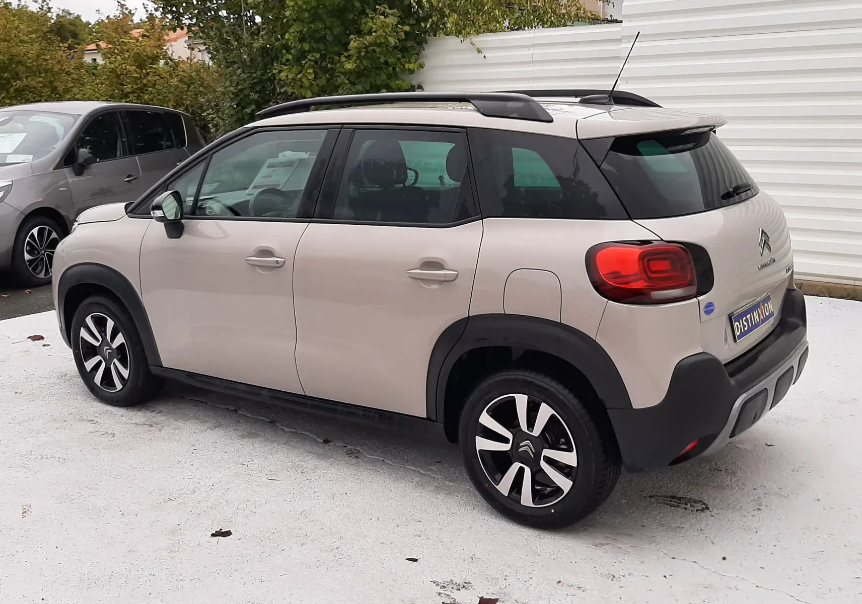 Vue 3/4 arrière droite d'une Citroën C3 Aircross sable métal avec toit noir et jantes alliage distinctives.