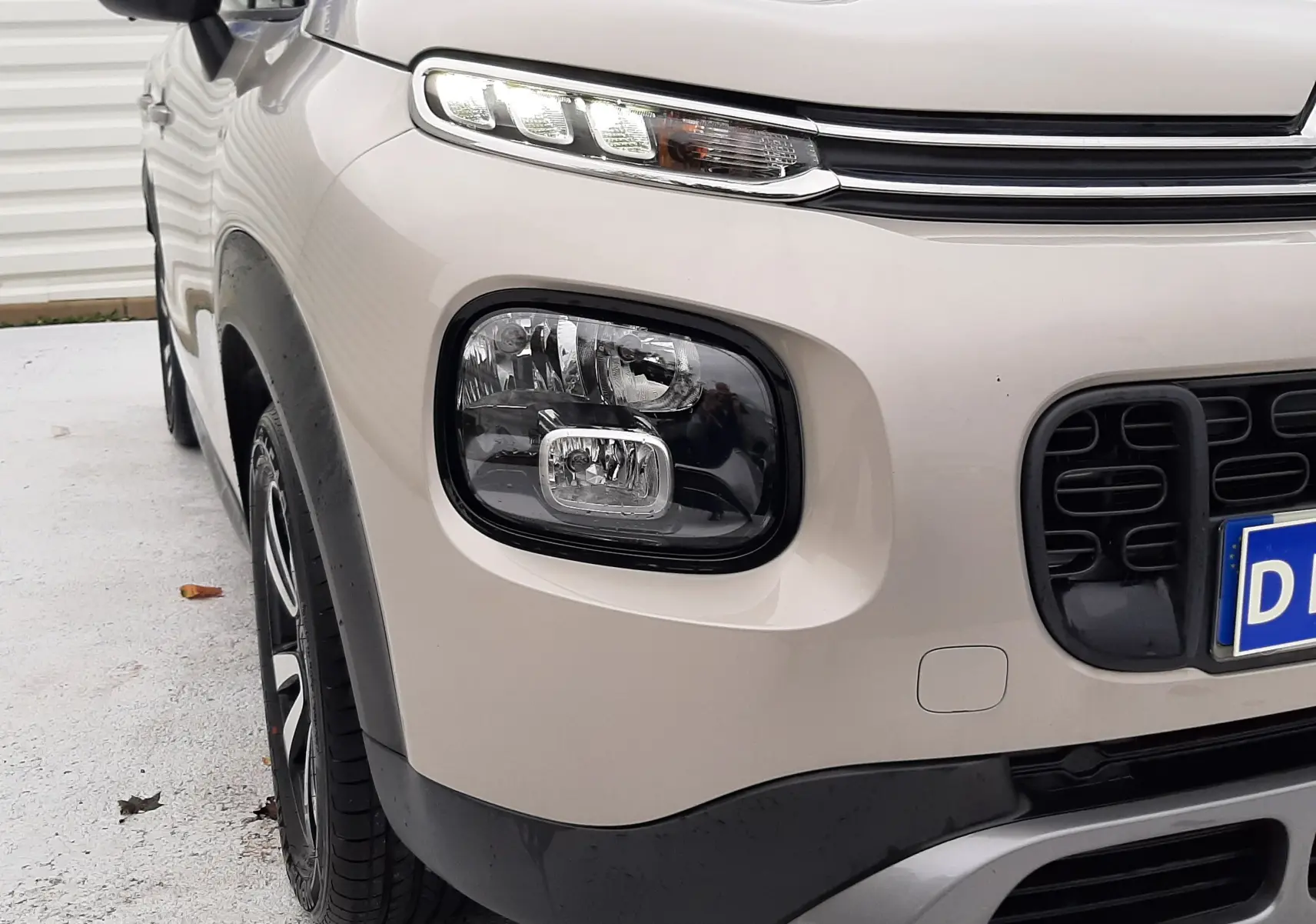 Vue de profil côté gauche d'une Citroën C3 Aircross 2021 sable métal avec jantes alliage et rétroviseur noir.
