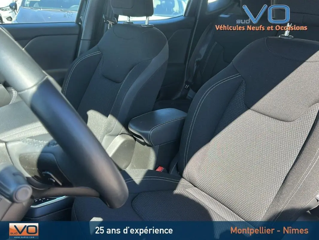 Intérieur du Jeep Renegade noir 2024, vue sur sièges avant avec accoudoir central et volant partiel.