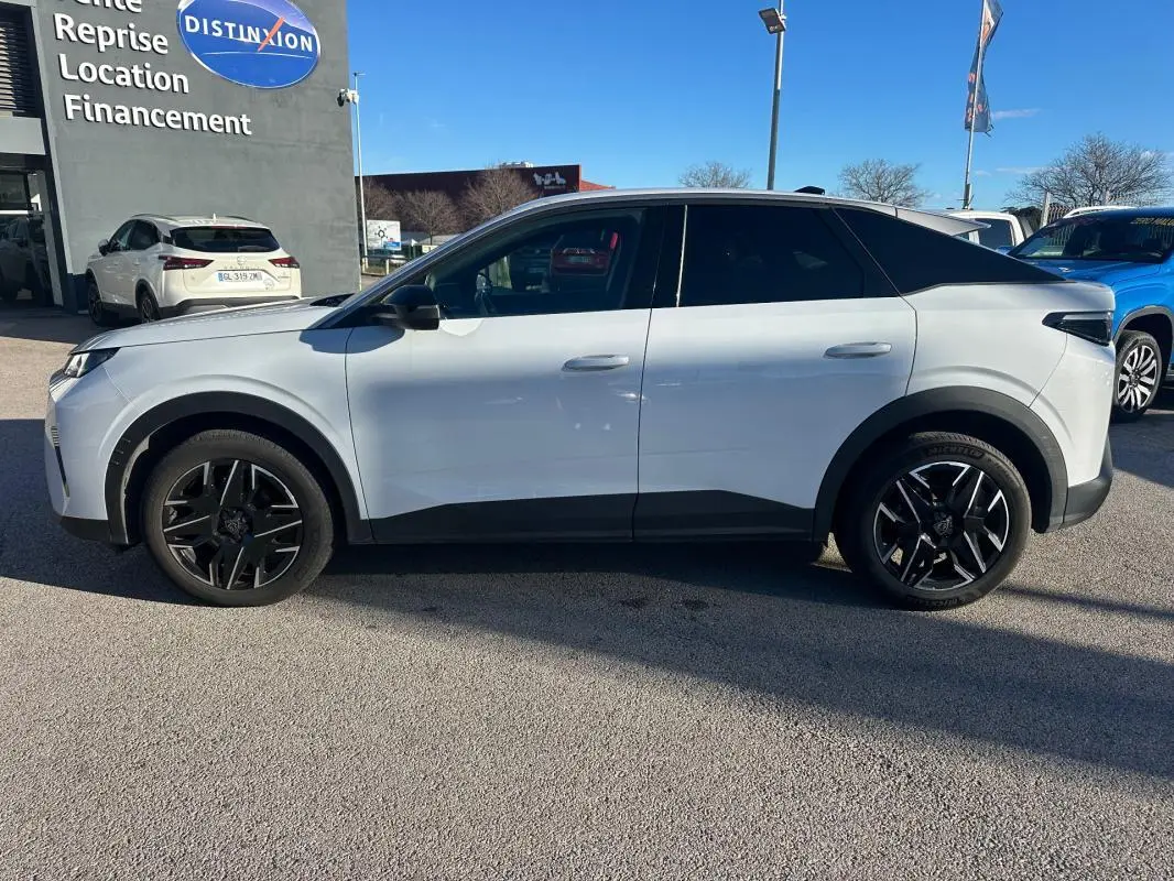 Vue de profil côté gauche d’un Peugeot 3008 Hybrid blanc avec jantes alliage noires de 19 pouces sur parking extérieur.