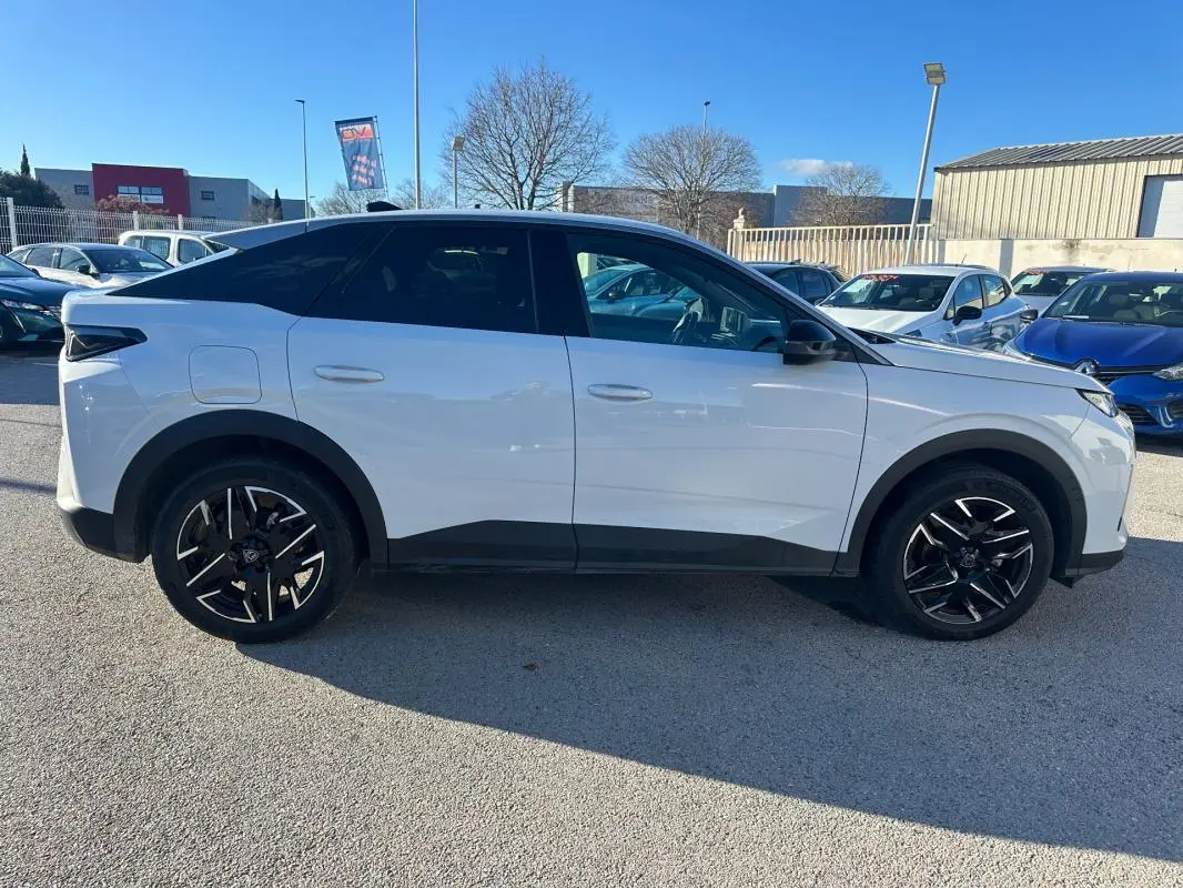 Peugeot 3008 Hybrid blanc vu de profil côté gauche, avec jantes alliage noires 19 pouces et toit noir contrasté.