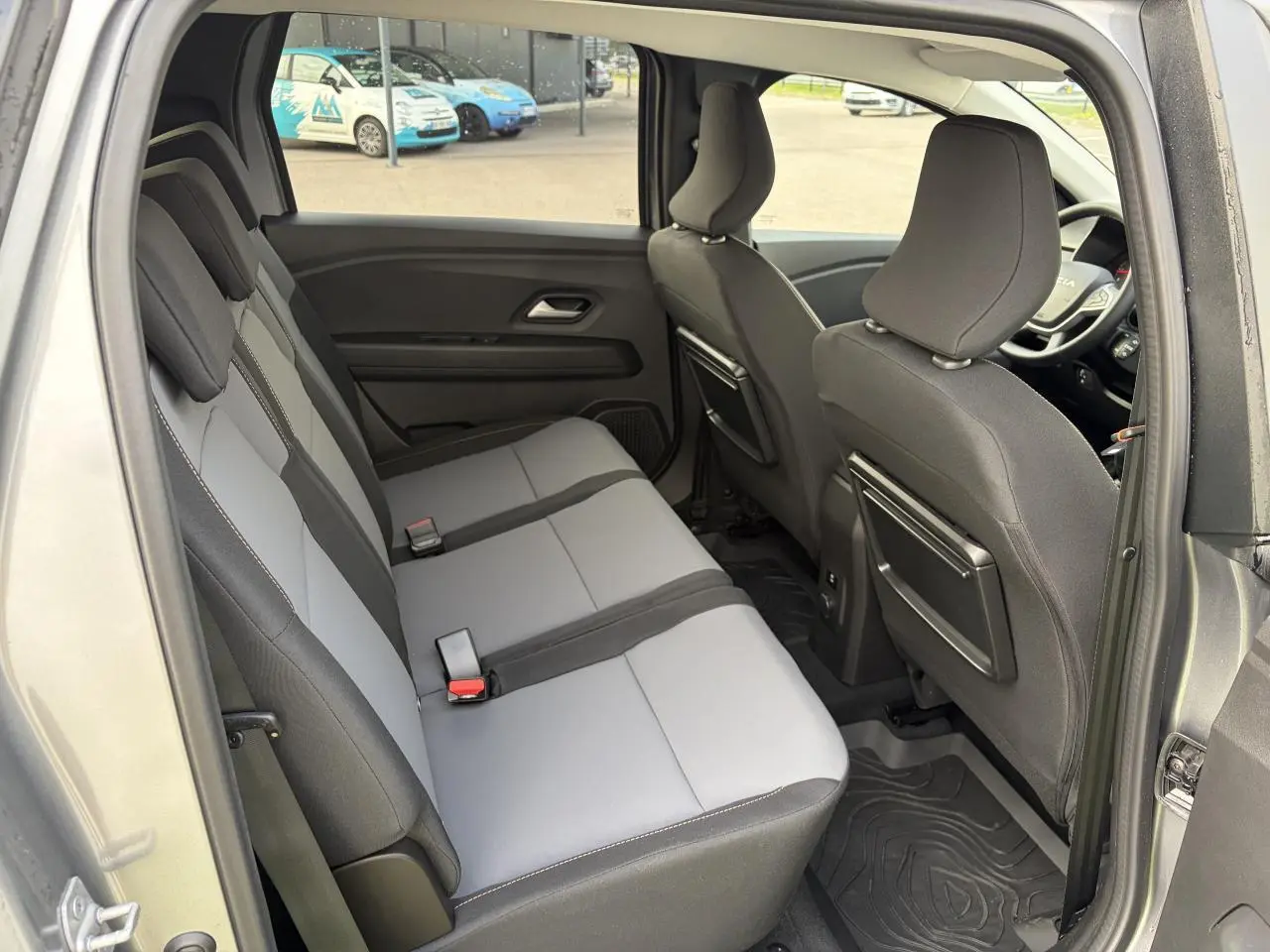 Vue intérieure côté gauche sur la banquette arrière grise et noire du Dacia Jogger 2025 avec rangements aux dossiers avant.