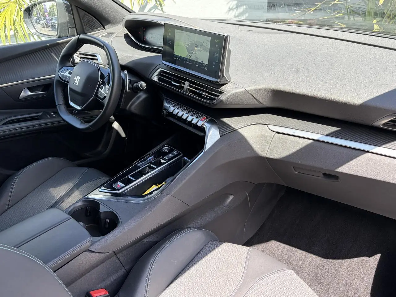 Vue intérieure côté conducteur du Peugeot 3008 Plug-in Hybrid 2024, tableau de bord noir avec écran tactile et volant compact.