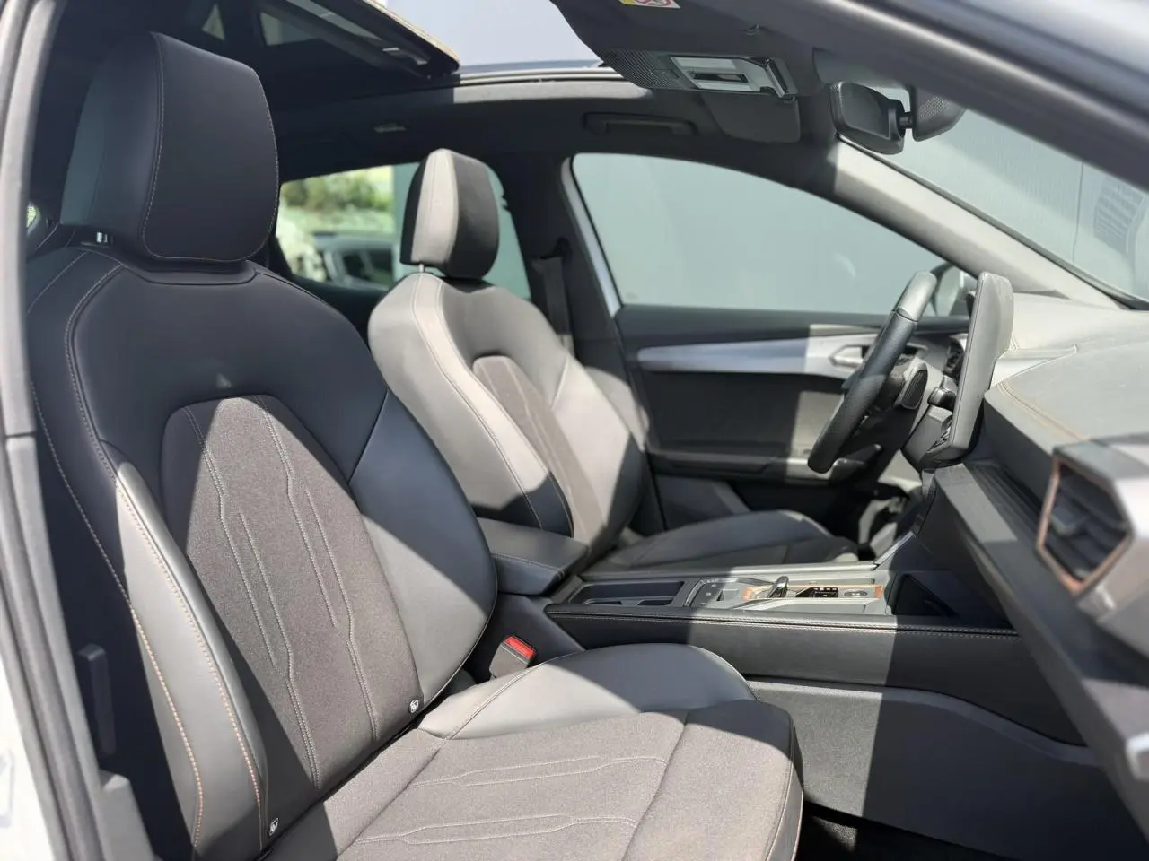 Vue intérieure côté conducteur du CUPRA Formentor blanc Neige 2025, sièges avant en cuir et alcantara avec toit ouvrant panoramique.