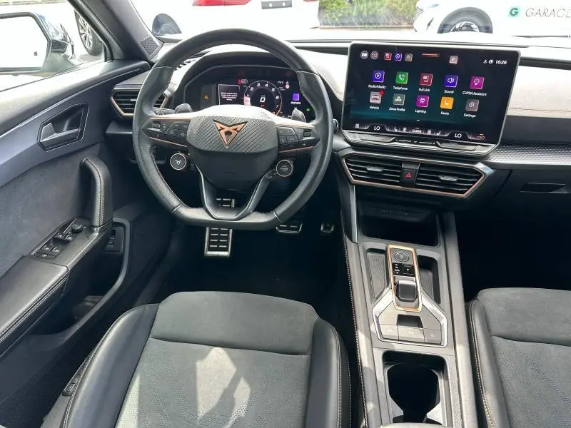 Vue intérieure frontale du poste de conduite noir du CUPRA Formentor 1.5 eTSI Hybrid avec écran tactile et volant multifonction.