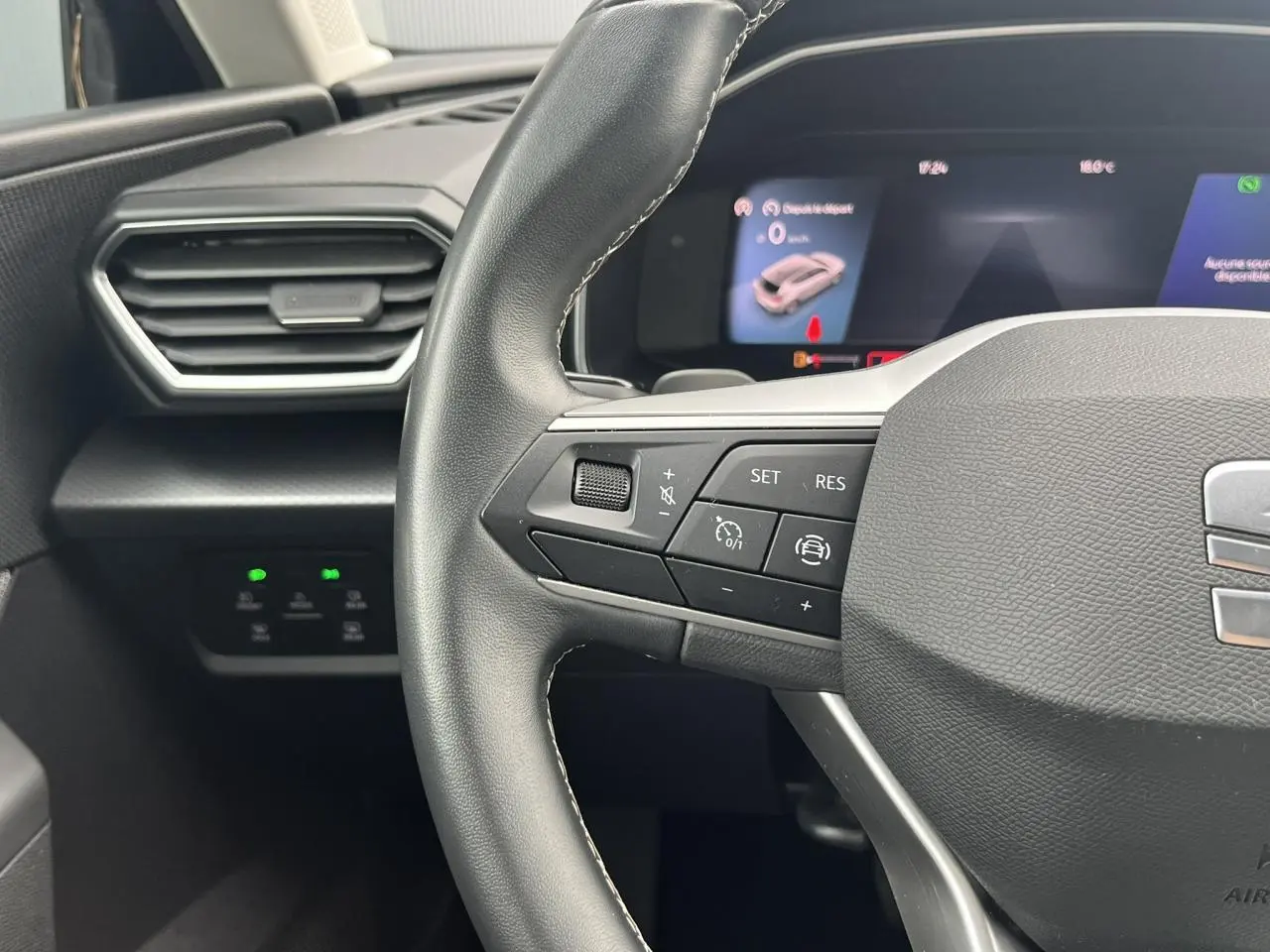 Gros plan sur le volant cuir multifonction côté gauche du SEAT LEON 2.0 TDI 150 DSG Style avec tableau de bord digital.