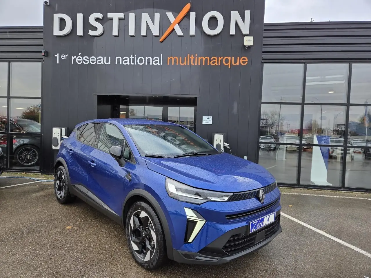 Silhouette stylisée bleue et orange d'une voiture avec le texte "en arrivage" sur fond blanc.