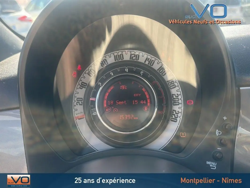 Tableau de bord circulaire de la Fiat 500 gris, affichant la vitesse, la température et l'odomètre à 15 392 km.