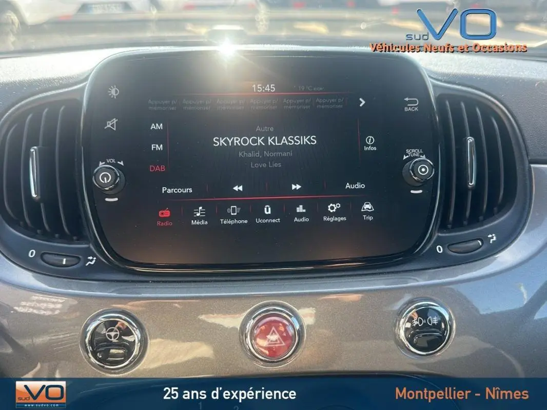 Tableau de bord de la FIAT 500 gris 2023, avec écran tactile central affichant la radio Skyrock Klassiks.