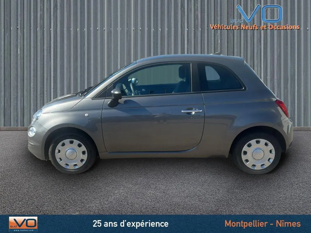 Profil côté gauche d'une FIAT 500 gris 2023, version hybride essence, avec jantes acier et carrosserie compacte.