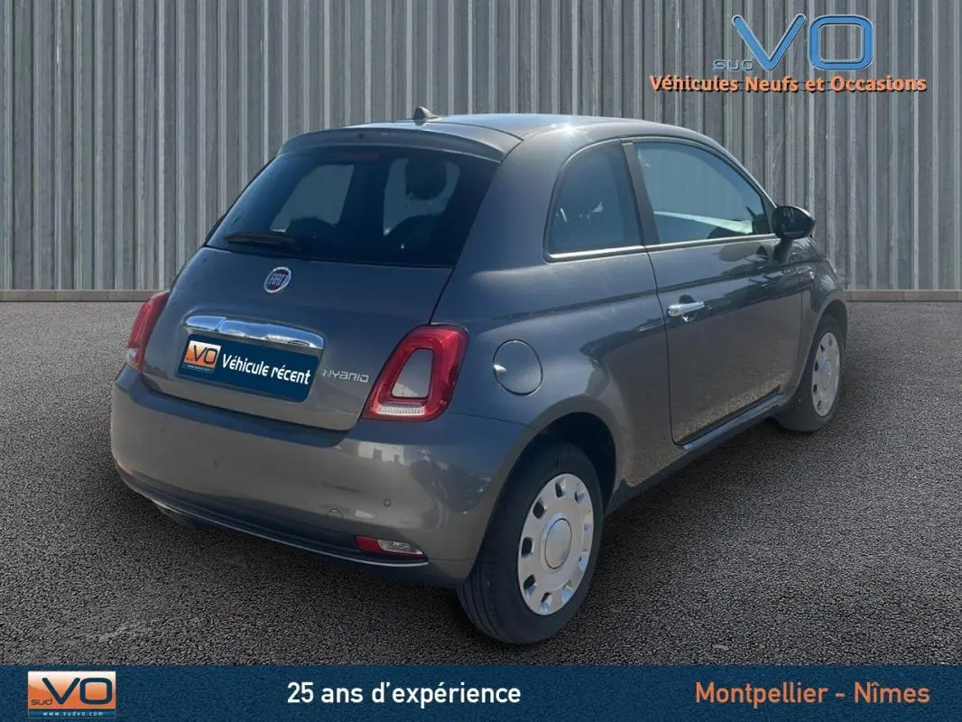 Vue 3/4 arrière droite d'une FIAT 500 gris 2023 hybride, avec jantes acier et logo distinctif sur le hayon.