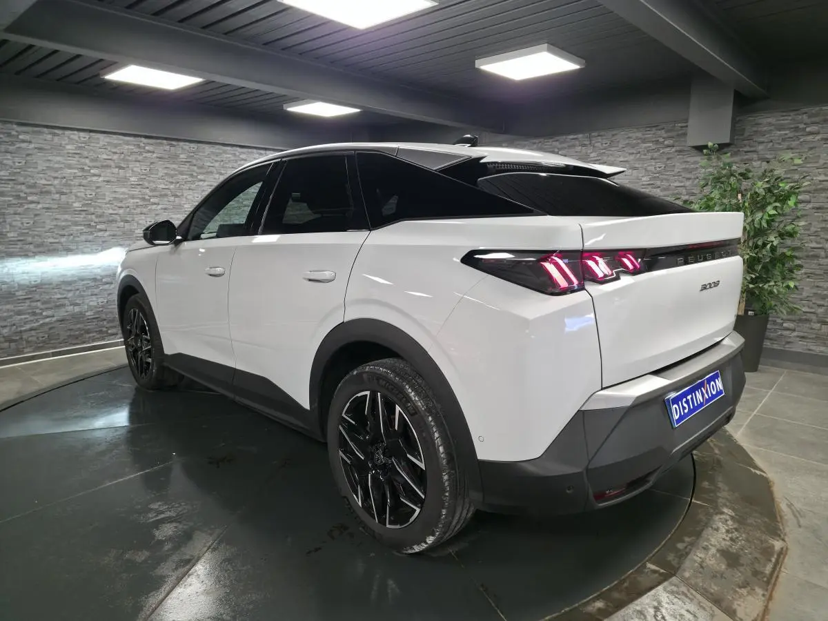 Peugeot 3008 blanc vue 3/4 arrière droit, jantes alliage noires et feux arrière LED 3 griffes allumés.