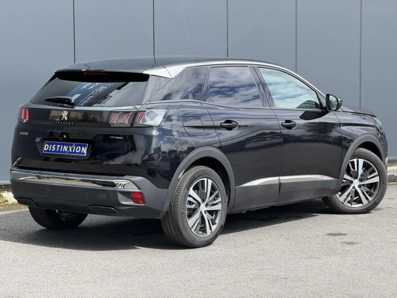 Vue 3/4 arrière droite du Peugeot 3008 Plug-in Hybrid noir Perla avec jantes alliage bi-ton et vitres surteintées.
