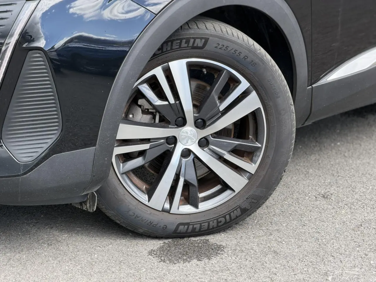 Gros plan sur la roue avant droite du Peugeot 3008 noir Perla avec jante alliage 18 pouces bi-ton diamantée.