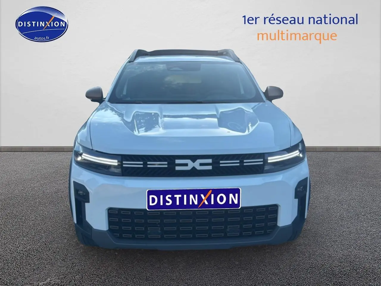 Vue frontale d'un Dacia Bigster blanc 2026 avec calandre noire et phares LED fins allumés.