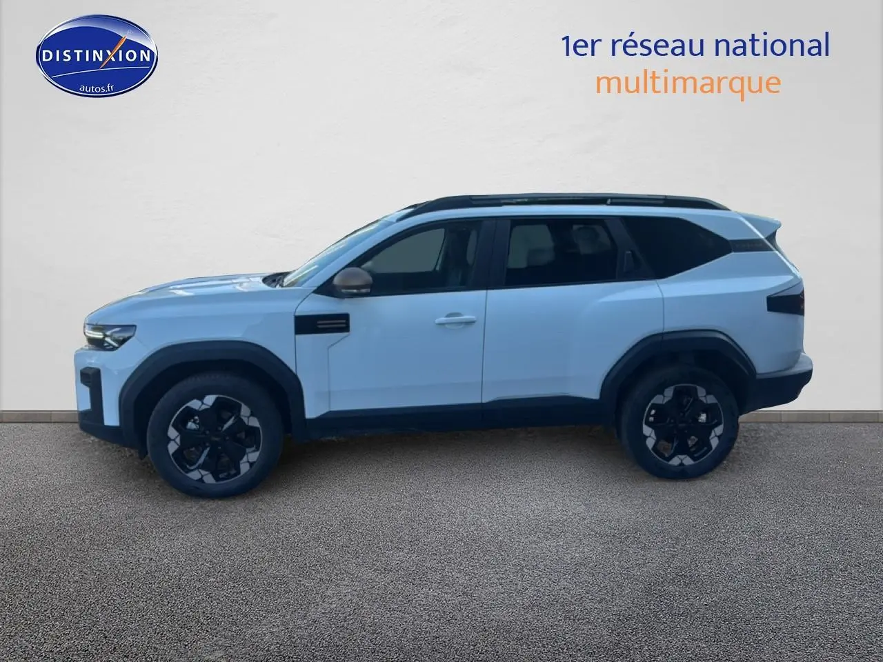 Profil droit du Dacia Bigster blanc 2026 avec jantes noires et barres de toit visibles.
