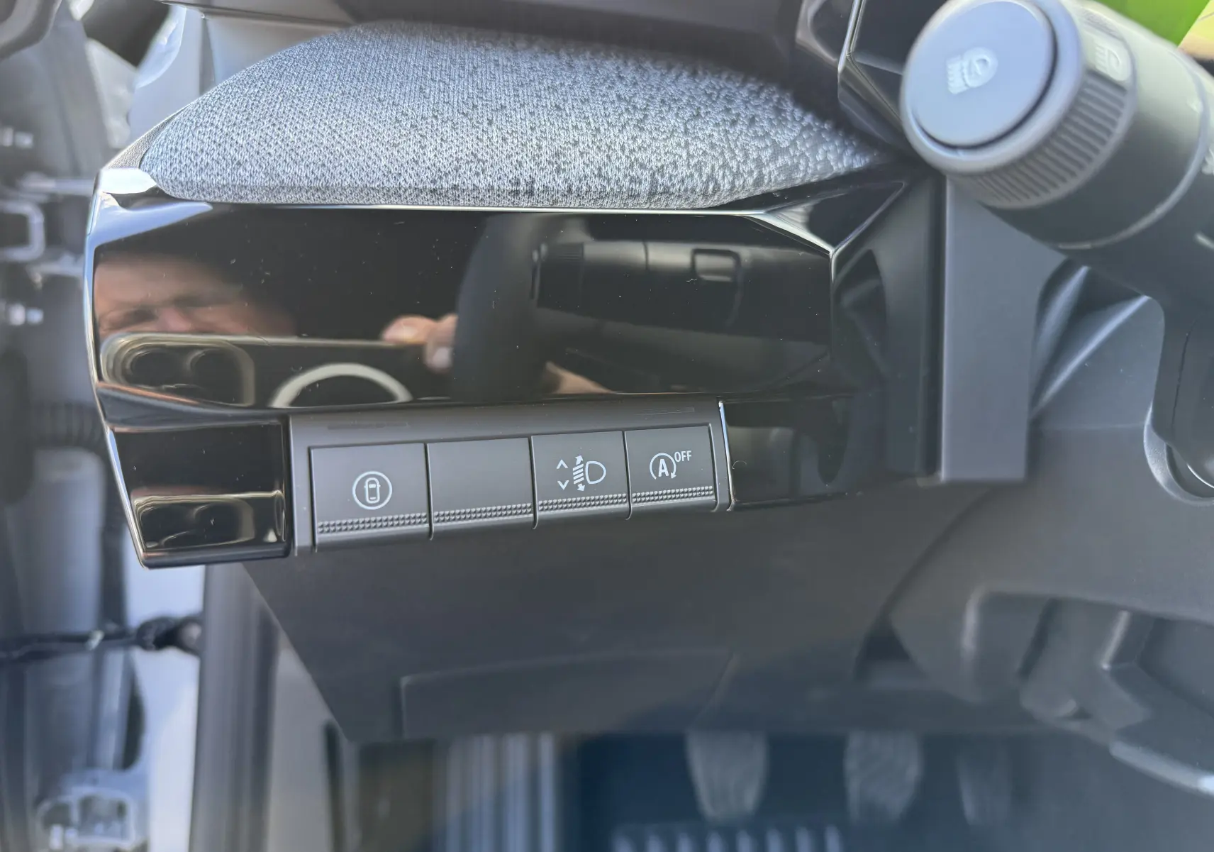 Détail des commandes sous le tableau de bord côté gauche de la Renault Clio VI TCE 115 Techno gris Rafale.