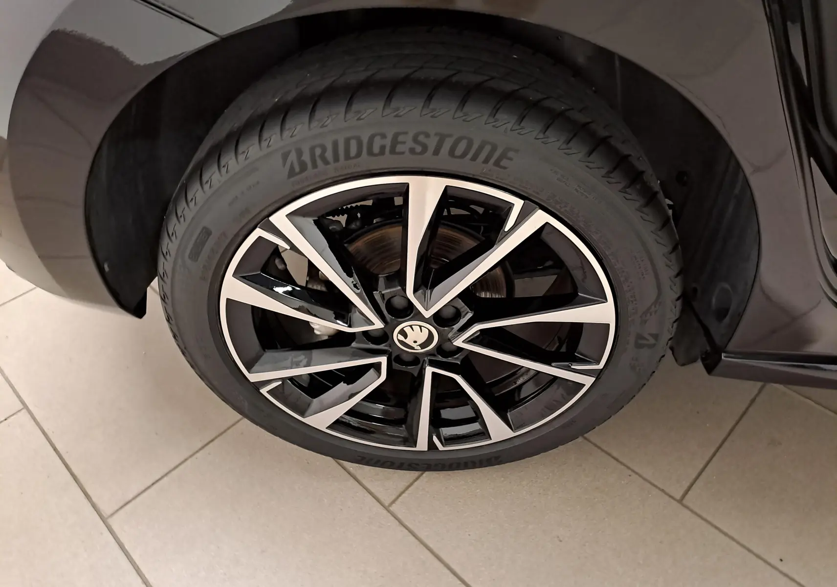 Gros plan sur la roue avant gauche de la Skoda Fabia 1.5 TSI 150 DSG7 Monte-Carlo en Noir Magic Nacré avec jante alliage bicolore.