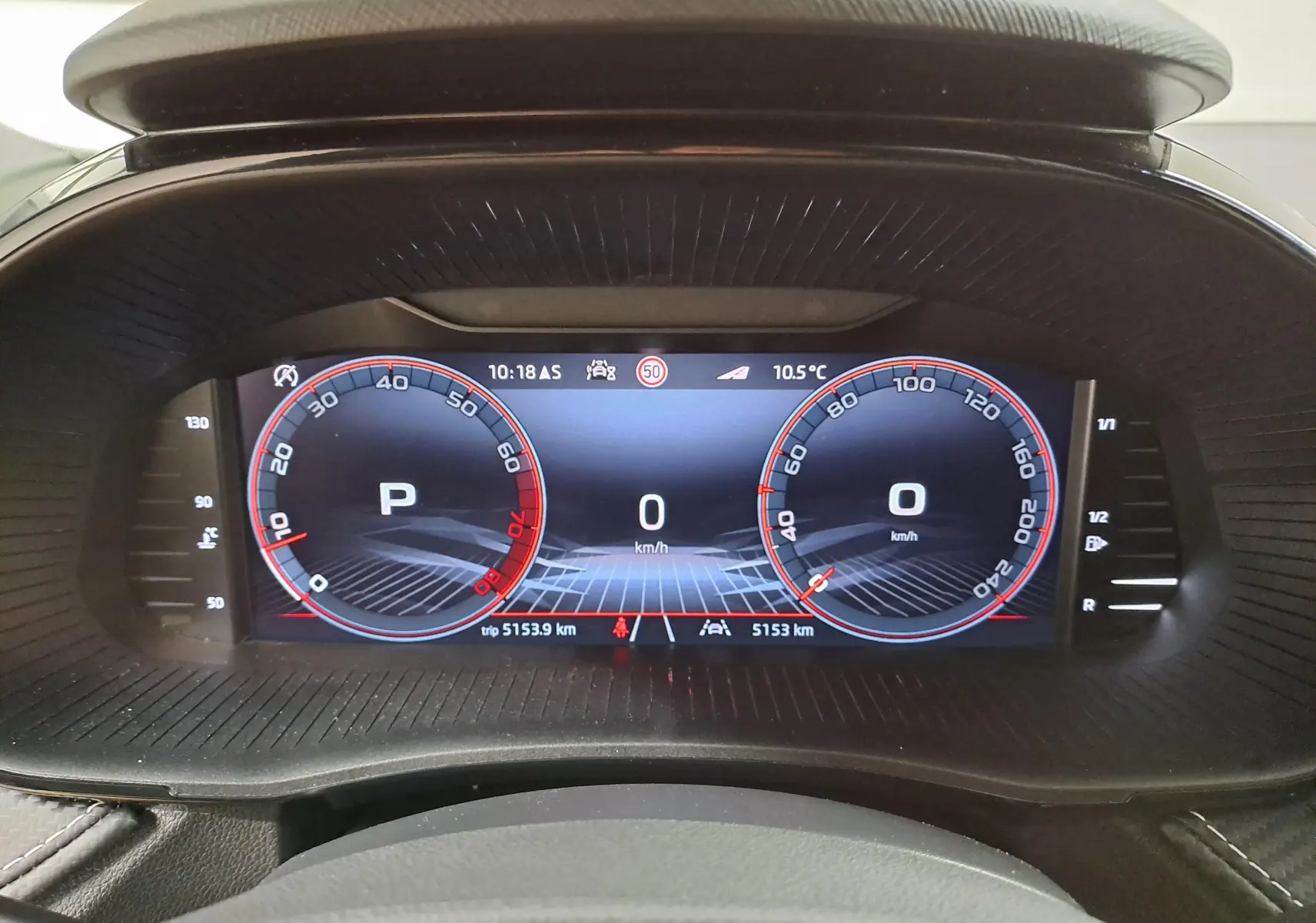 Tableau de bord numérique de la Skoda Fabia 2024 affichant la vitesse et le mode parking, vue frontale intérieure.