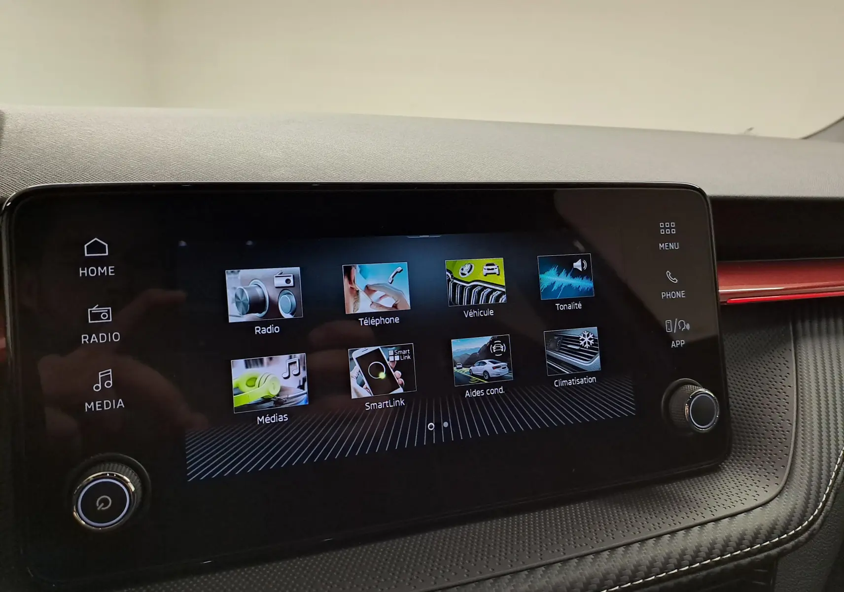 Écran tactile central de la Skoda Fabia 2024 affichant les menus radio, téléphone, véhicule et climatisation, intérieur noir avec surpiqûres.