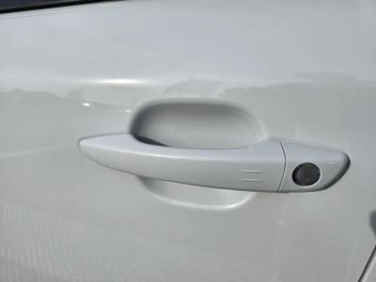 Gros plan sur l'emblème GT noir brillant sur la portière blanche du Peugeot 2008 II hybride 2025.