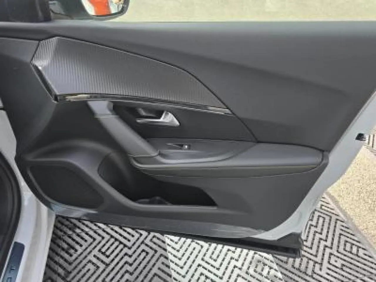 Poignée de porte blanche côté gauche du Peugeot 2008 hybride 2025 avec capteur d'ouverture intégré.