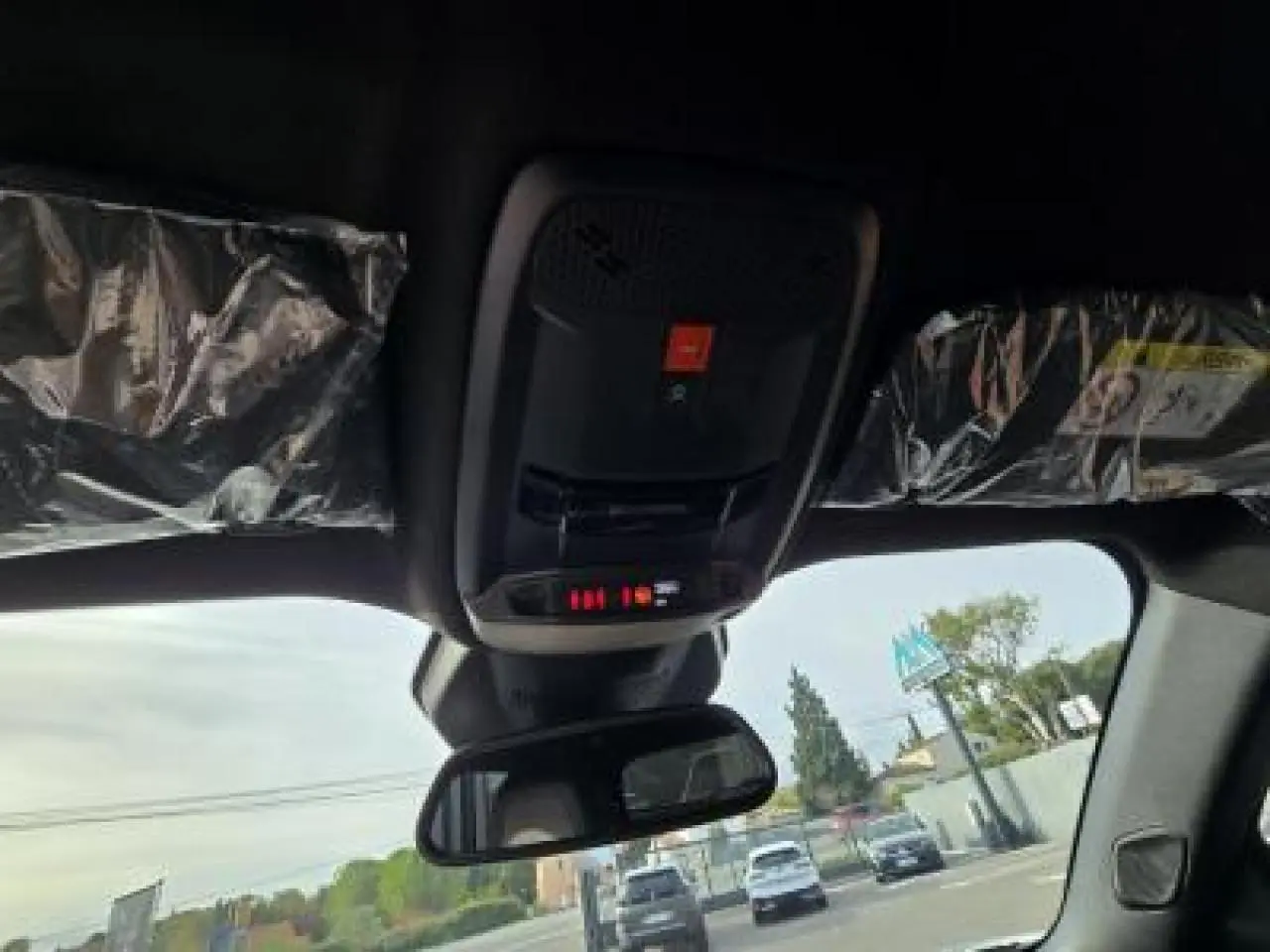 Gros plan sur la palette de changement de vitesse + du volant au cuir noir avec surpiqûres vertes du Peugeot 2008 hybride blanc.