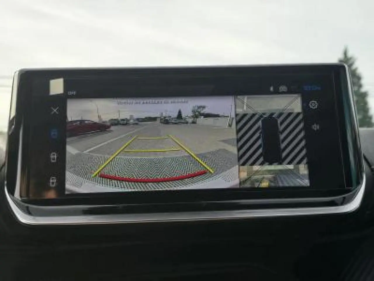 Vue intérieure du plafond avant du Peugeot 2008 blanc avec commandes d'éclairage et rétroviseur central visible