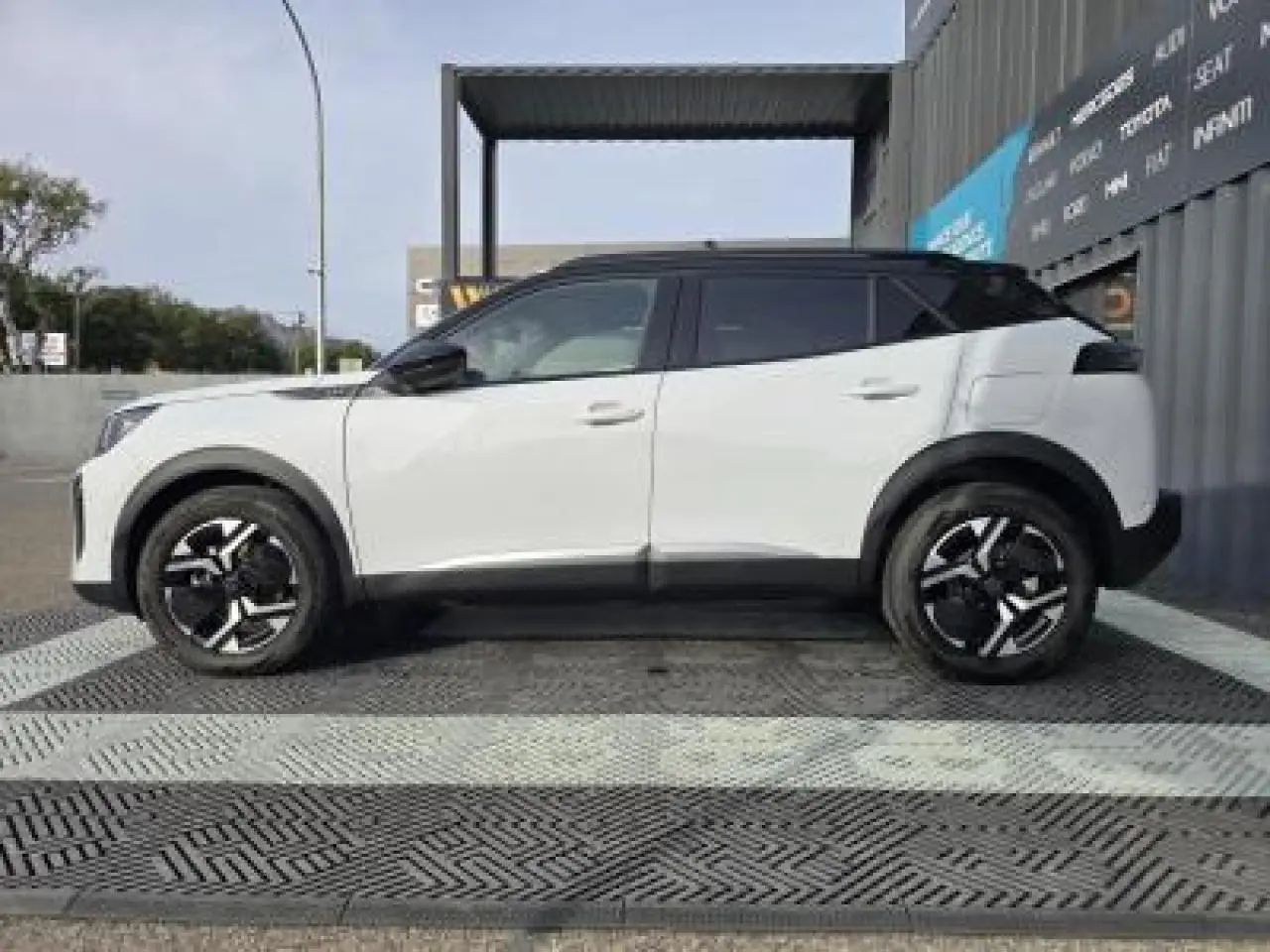 Vue 3/4 arrière droite du Peugeot 2008 blanc Okenite avec toit noir et jantes alliage bi-ton 17 pouces.