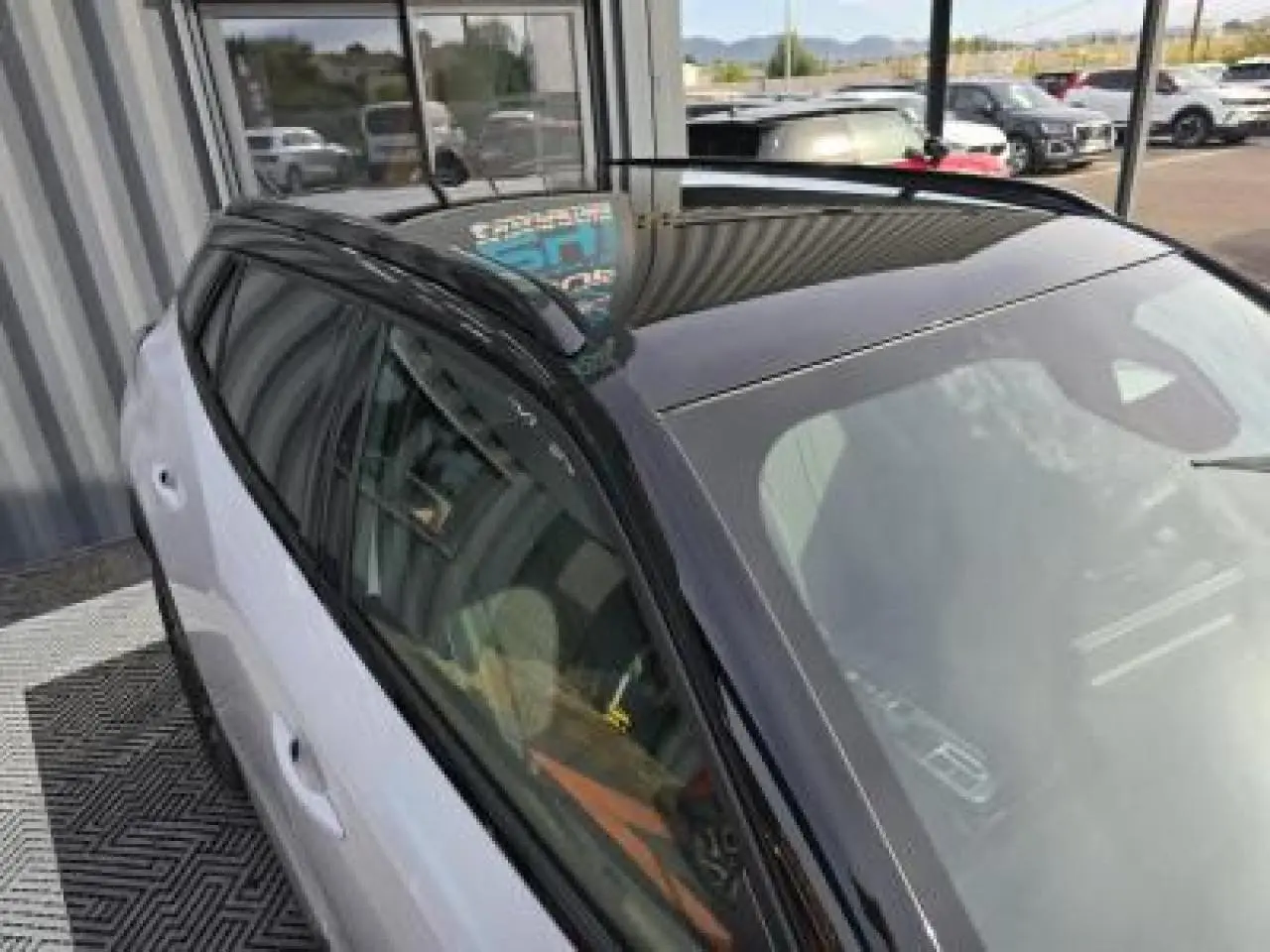 Vue 3/4 arrière droite du Peugeot 2008 blanc Okenite avec toit noir et jantes alliage bi-ton 17 pouces.