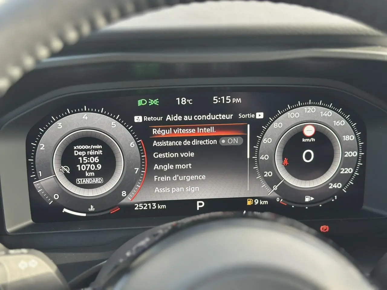 Tableau de bord numérique du Nissan Qashqai 2025 affichant les aides à la conduite et compteurs en vue frontale.