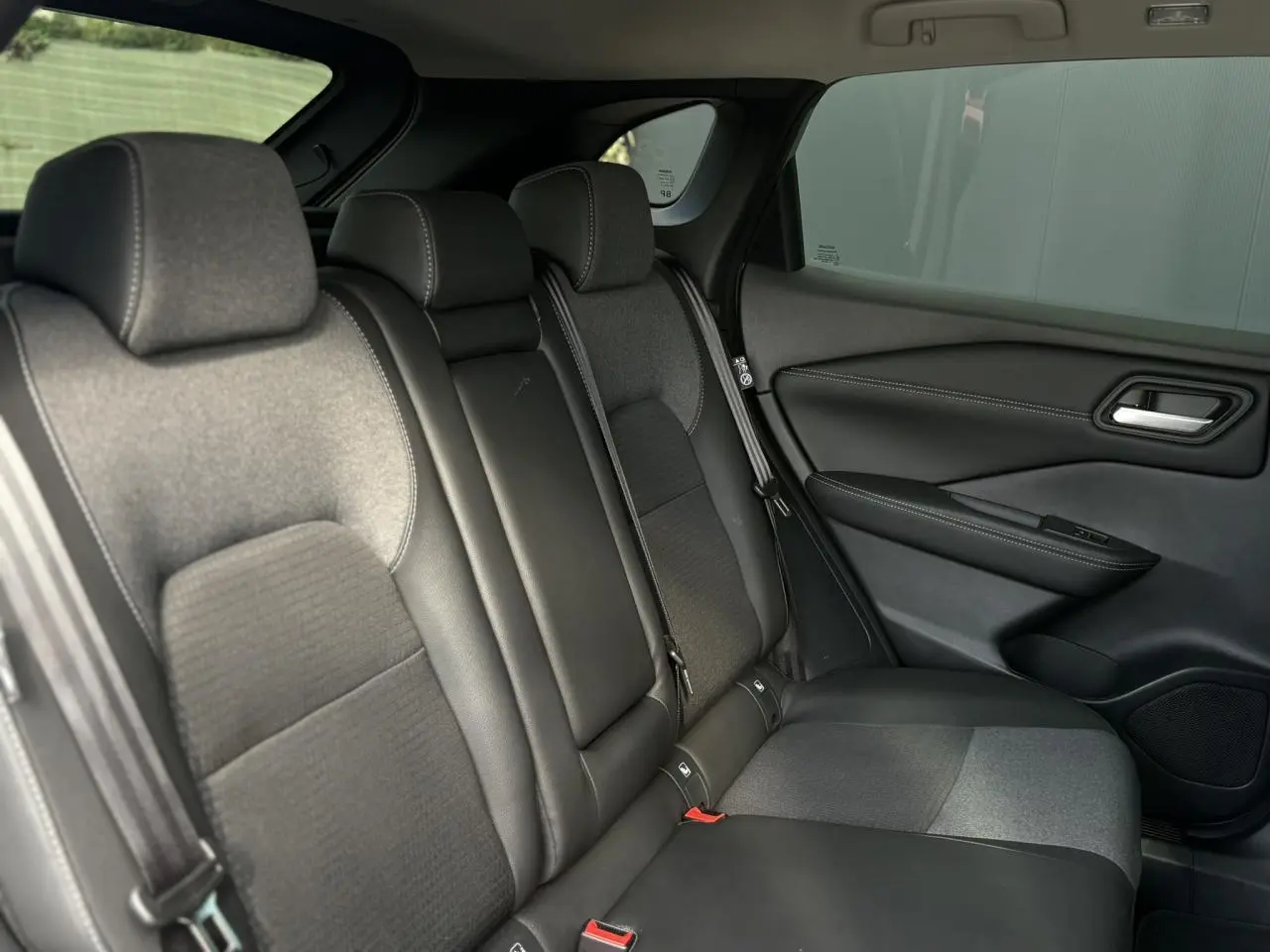 Vue côté droit de la banquette arrière du Nissan Qashqai 2025 avec sellerie mixte noire en tissu et TEP.