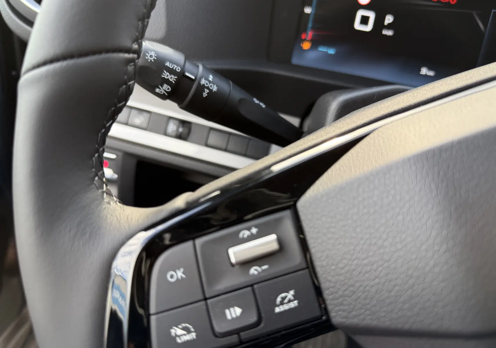 Gros plan sur les commandes au volant noir du Citroën Jumpy Cabine Approfondie 2026, affichage digital en arrière-plan.