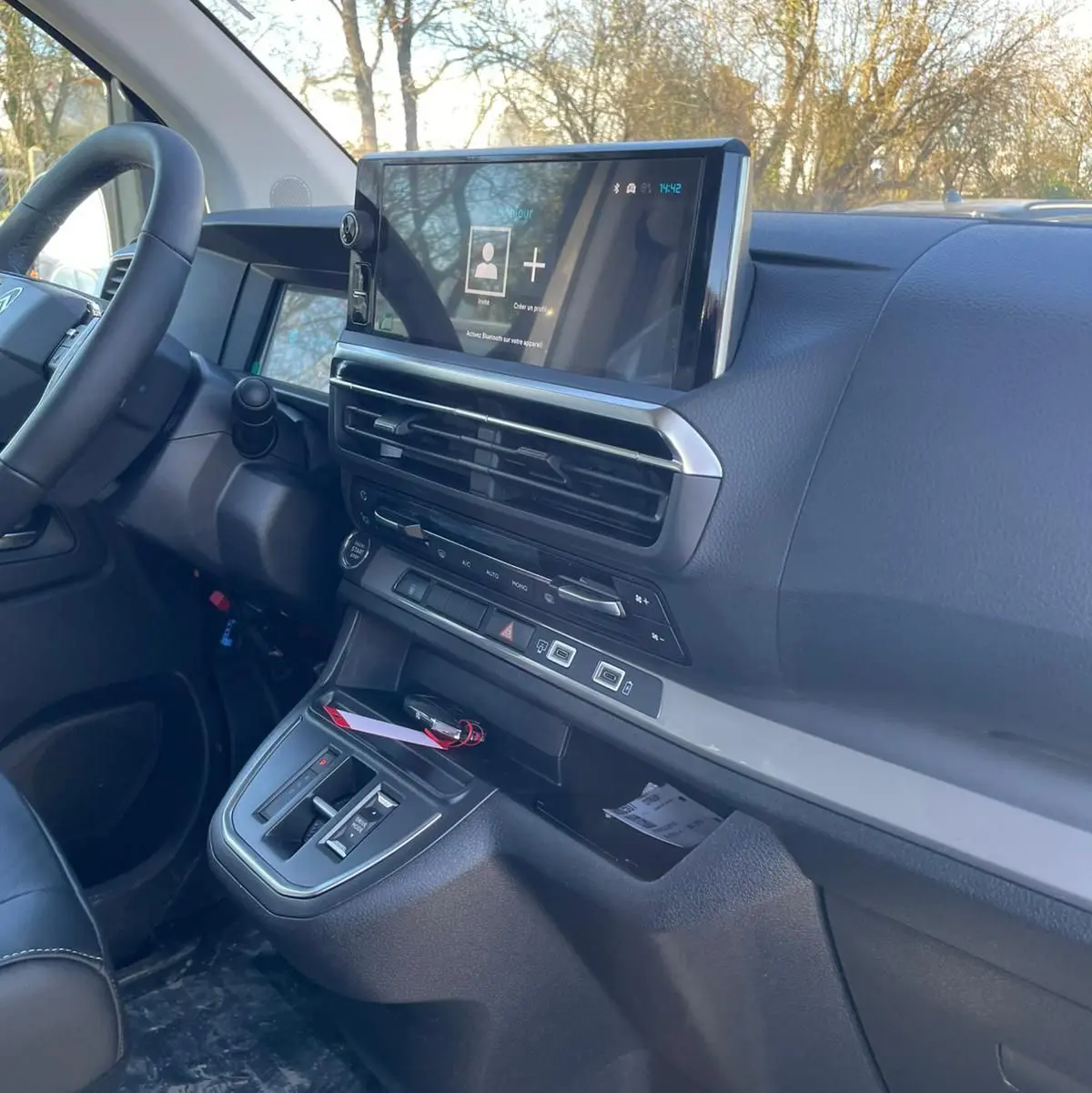 Écran numérique du tableau de bord du Citroën Jumpy cabine approfondie noir Perla, affichant la radio et l'état du véhicule.