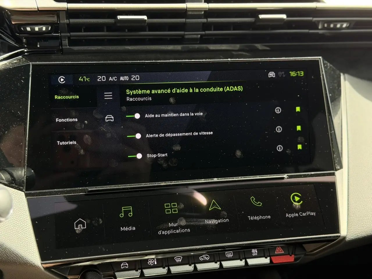 Écran tactile intérieur de la Peugeot 308 Hybrid affichant les aides à la conduite, avec tableau de bord clair.
