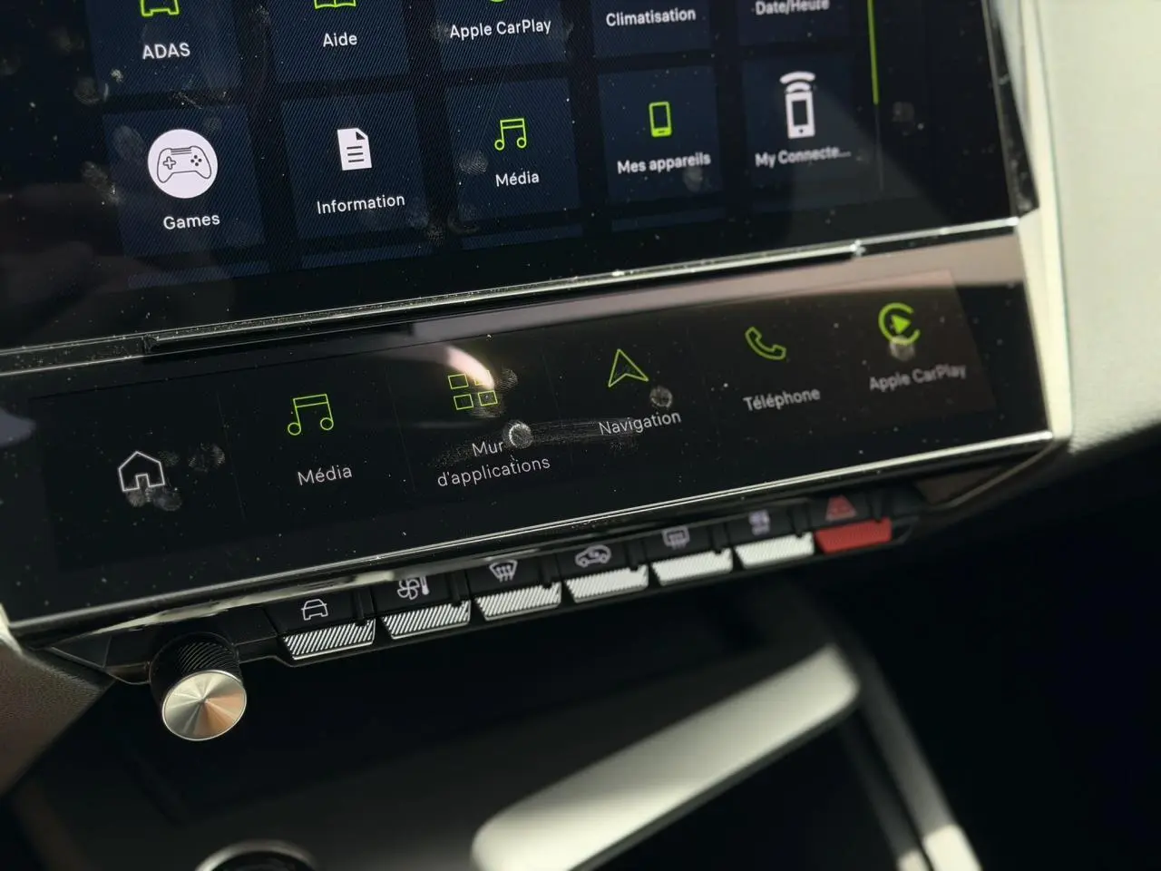 Gros plan sur l’écran tactile central et les commandes de la Peugeot 308 NV Hybrid 145 GT e-DSC6 blanche, intérieur moderne.