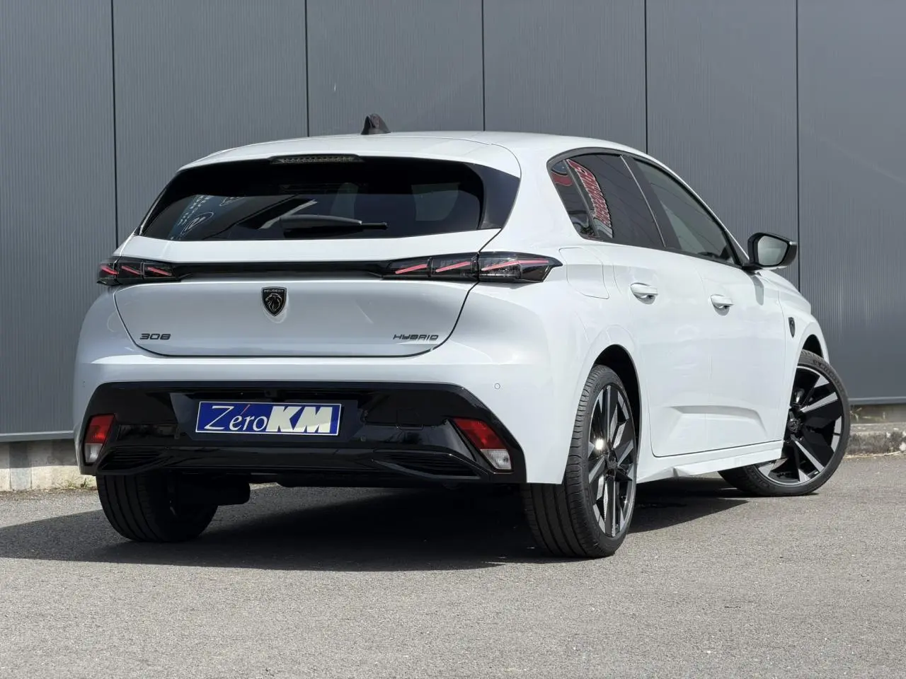 PEUGEOT 308 NV Hybrid blanc Okenite en 3/4 arrière droit, jantes alliage bi-tons et feux arrière LED 3 griffes.