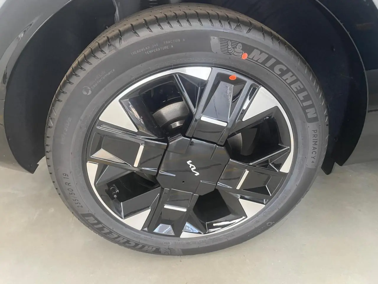 Gros plan sur la jante noire et argentée du KIA SPORTAGE Hybride 239 ch 2026 avec logo KIA au centre.