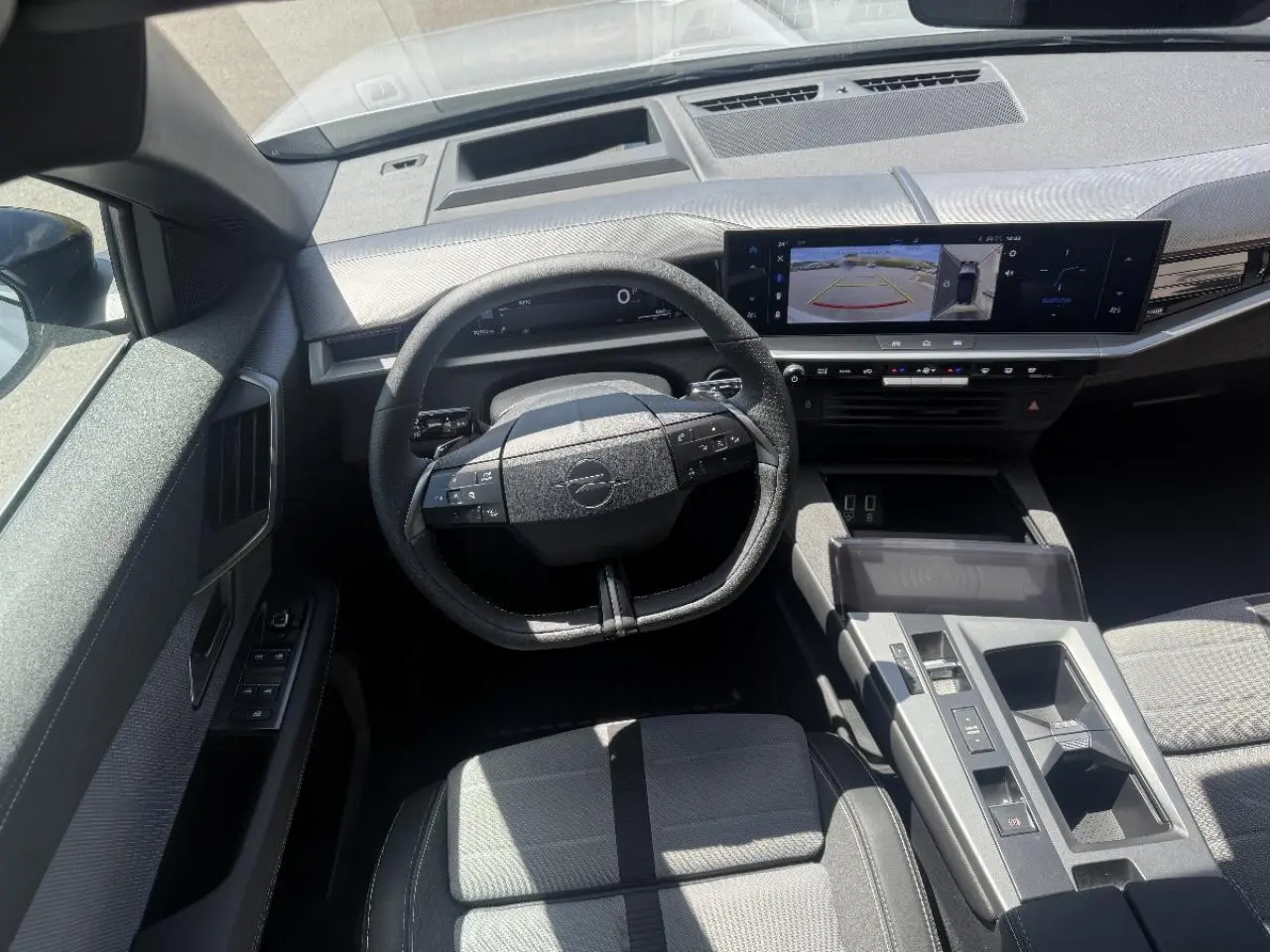 Vue intérieure avant de l’Opel Grandland gris kristall 2025, montrant le volant multifonction et l’écran tactile large.