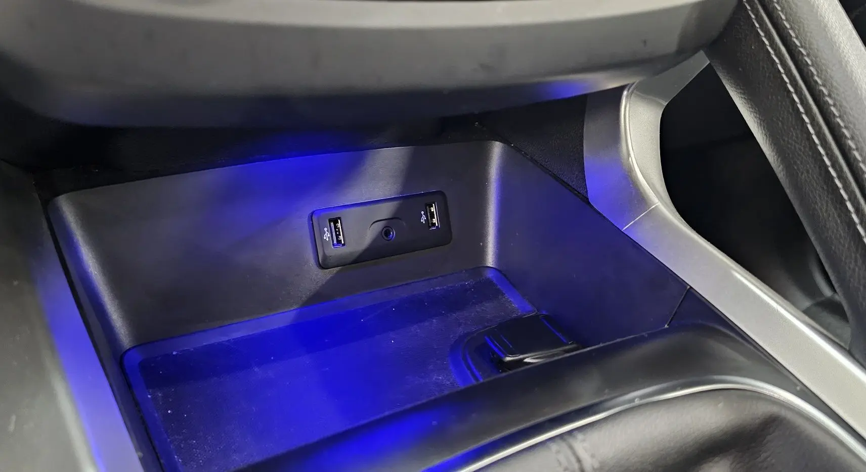 Gros plan sur la console centrale du Renault Kadjar 2021, avec éclairage bleu et ports USB visibles.